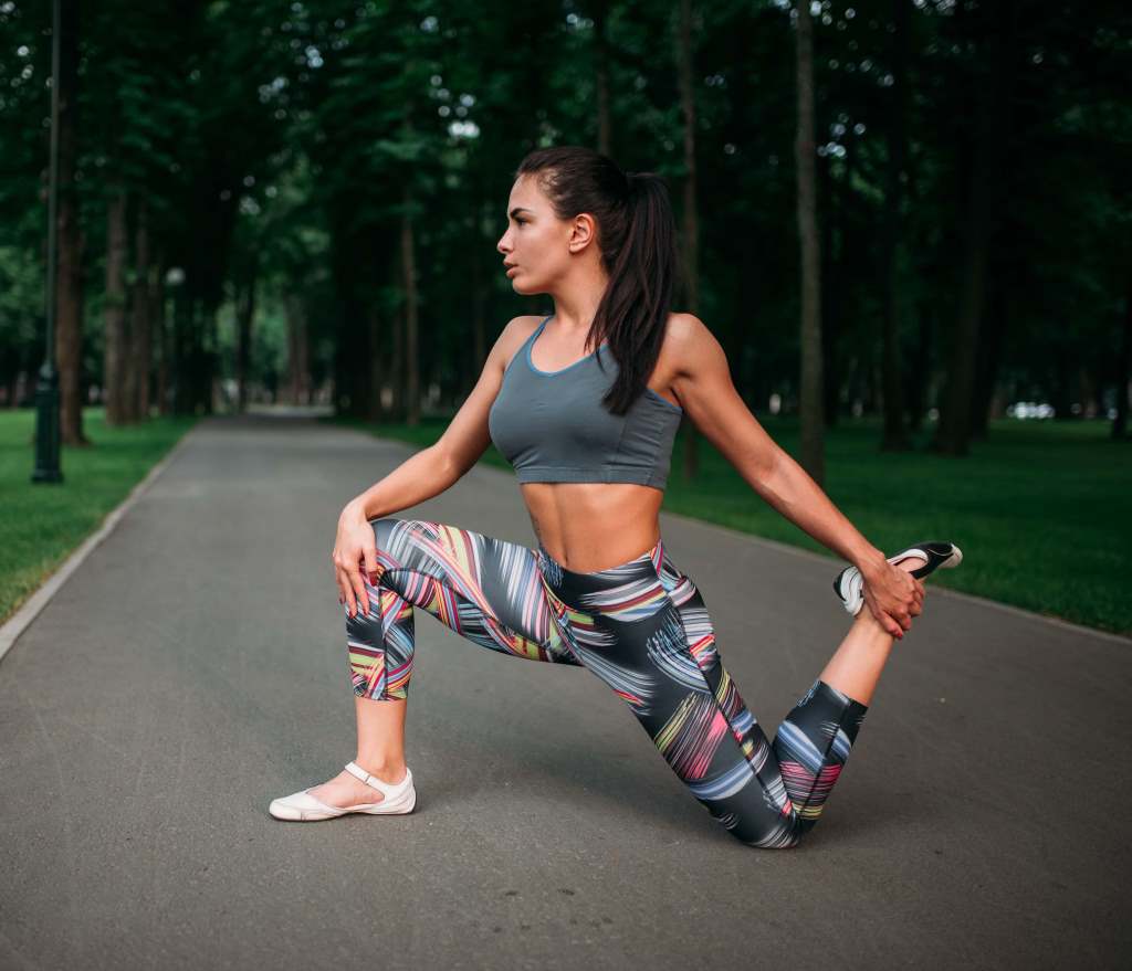 mujer en leggings deportivo estampado y top deportivo haciendo ejercicio