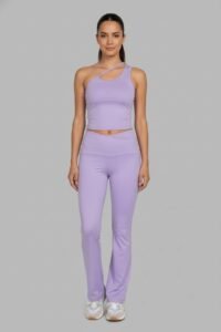 A174. Conjunto Lila Mallón Acampanado Pretina en "V" y Top con Tirante Cruzado 3 mujer usando un conjunto deportivo de top y malla acampanada color lila